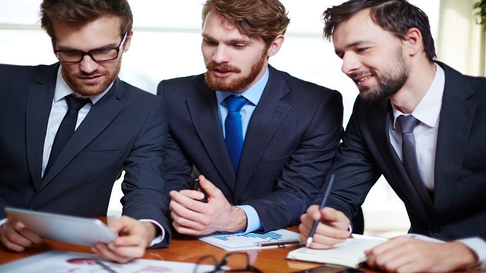 Group of managers discussing electronic document or data in touchpad