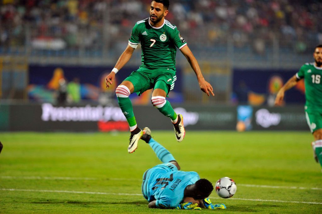 Algeria's Riyad Mahrez jumps over Senegal's goalkeeper Edouard Osoque Mendy during the African Cup of Nations group C soccer match between Algeria and Senegal at 30 June Stadium in Cairo, Egypt, Thursday, June 27, 2019. (Photo by Mohamed Mostafa/NurPhoto via Getty Images)