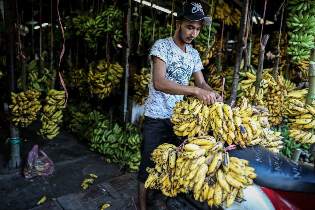 A man prepares bananas for sale at a traditional market in Jakarta, Indonesia, on July 7, 2019. (Photo by Andrew Gal/NurPhoto via Getty Images)