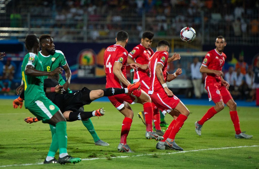 CAIRO, EGYPT - JULY 14: Goalkeeper Hassen Mouez of Tunisia dives to clear the ball but misses it as the ball hits Dylan Bronn, conceding an own goal during the 2019 Africa Cup of Nations Semi Final match between Senegal and Tunisia at 30th June Stadium on July 14, 2019 in Cairo, Egypt. (Photo by Visionhaus)