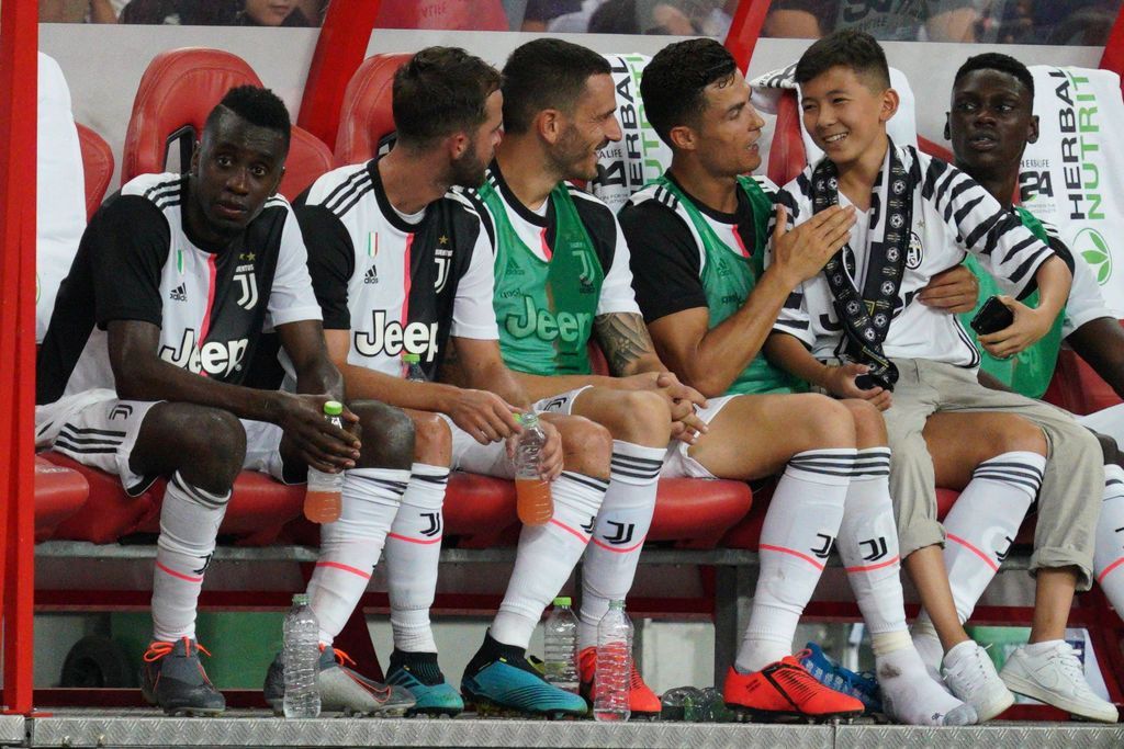 SINGAPORE, SINGAPORE - JULY 21: Cristiano Ronaldo of Juventus talks to a young fan at the substitute bench when the boy ran to him from across the field illegally during the International Champions Cup match between Juventus and Tottenham Hotspur at the Singapore National Stadium on July 21, 2019 in Singapore. (Photo by Allsport Co./Getty Images)