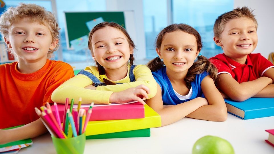 Portrait of cheerful school children flashing toothy smiles