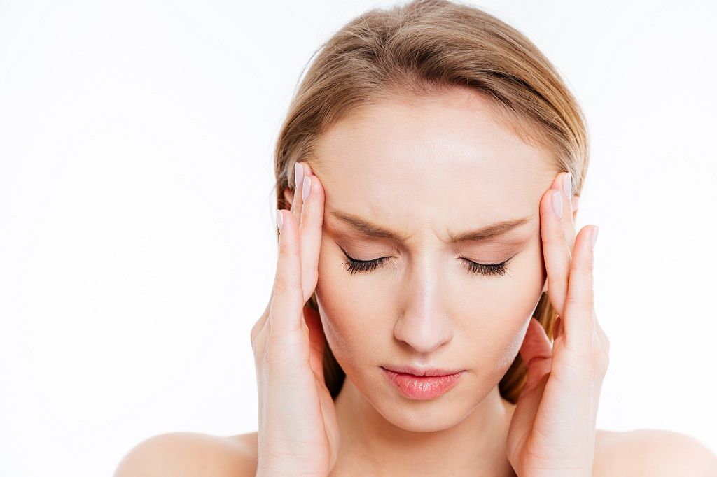 Closeup portrait of a young woman with headache isolated on a white background - storyblocks