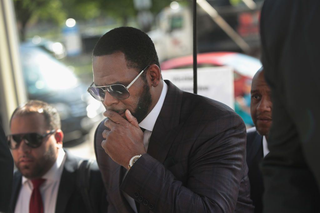 CHICAGO, ILLINOIS - JUNE 26: R&B singer R. Kelly covers his mouth as he speaks to members of his entourage as he arrives at the Leighton Criminal Courts Building for a hearing on June 26, 2019 in Chicago, Illinois. Kelly is facing several counts of aggravated sexual abuse. (Photo by Scott Olson/Getty Images)