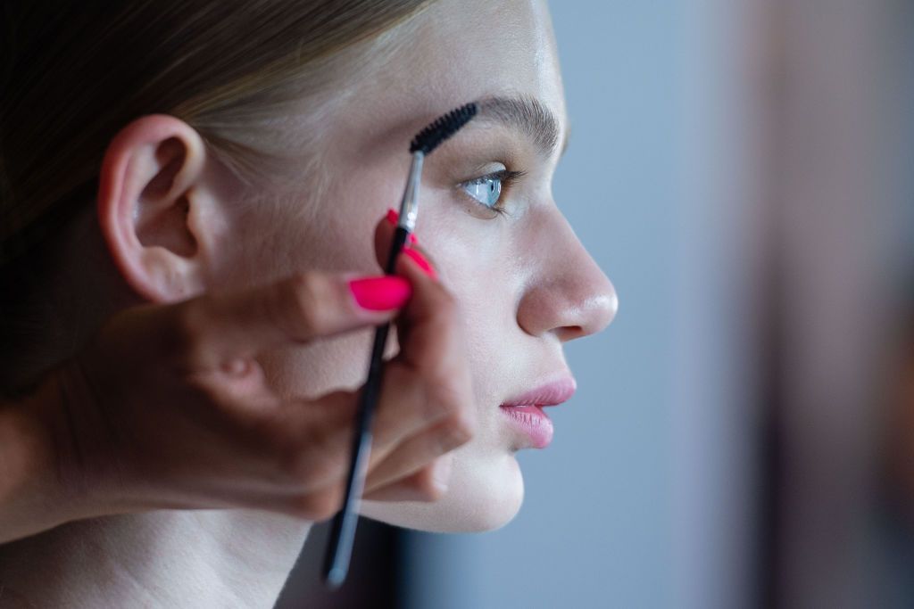 03 July 2019, Berlin: A make-up stylist takes care of the eyebrows of a model for the show of designer Marcel Ostertag. The collections for Spring/Summer 2020 will be presented at Berlin Fashion Week. Photo: Lisa Ducret/dpa (Photo by Lisa Ducret/picture alliance via Getty Images)