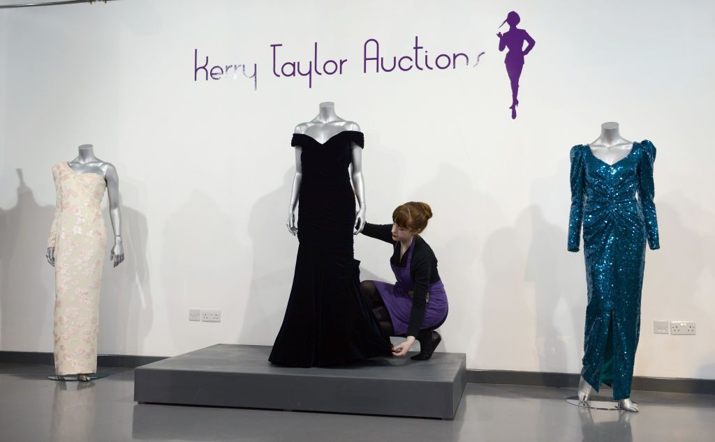 LONDON, UNITED KINGDOM - MARCH 15: Victor Edelstein Midnight Blue Velvet Gown worn for a State dinner at the White House when Diana danced with John Travolta in November 1985 (C) is displayed at a photocall ahead of the the 'Fit For a Princess' auction on March 15, 2013 in London, England. 10 dresses from the collection of Diana, Princess of Wales are to be auctioned by specialist Kerry Taylor. (Photo by Karwai Tang/WireImage)