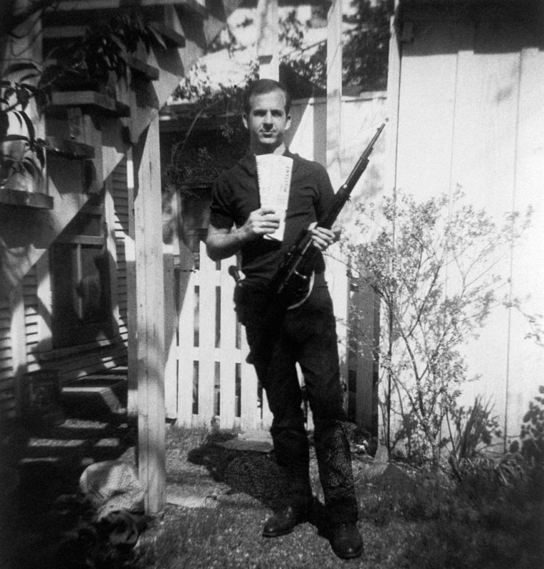 Lee Harvey Oswald holds a Mannlicher-Carcano rifle and newspapers in a backyard. This photograph is one of the controversial backyard photos used in the assassination of John F. Kennedy investigation in 1963. (Photo by © CORBIS/Corbis via Getty Images)