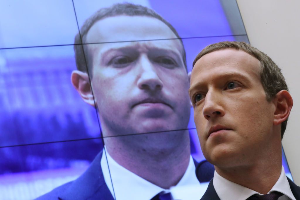 WASHINGTON, DC - OCTOBER 23: With an image of himself on a screen in the background, Facebook co-founder and CEO Mark Zuckerberg testifies before the House Financial Services Committee in the Rayburn House Office Building on Capitol Hill October 23, 2019 in Washington, DC. Zuckerberg testified about Facebook's proposed cryptocurrency Libra, how his company will handle false and misleading information by political leaders during the 2020 campaign and how it handles its users’ data and privacy. (Photo by Chip Somodevilla/Getty Images)