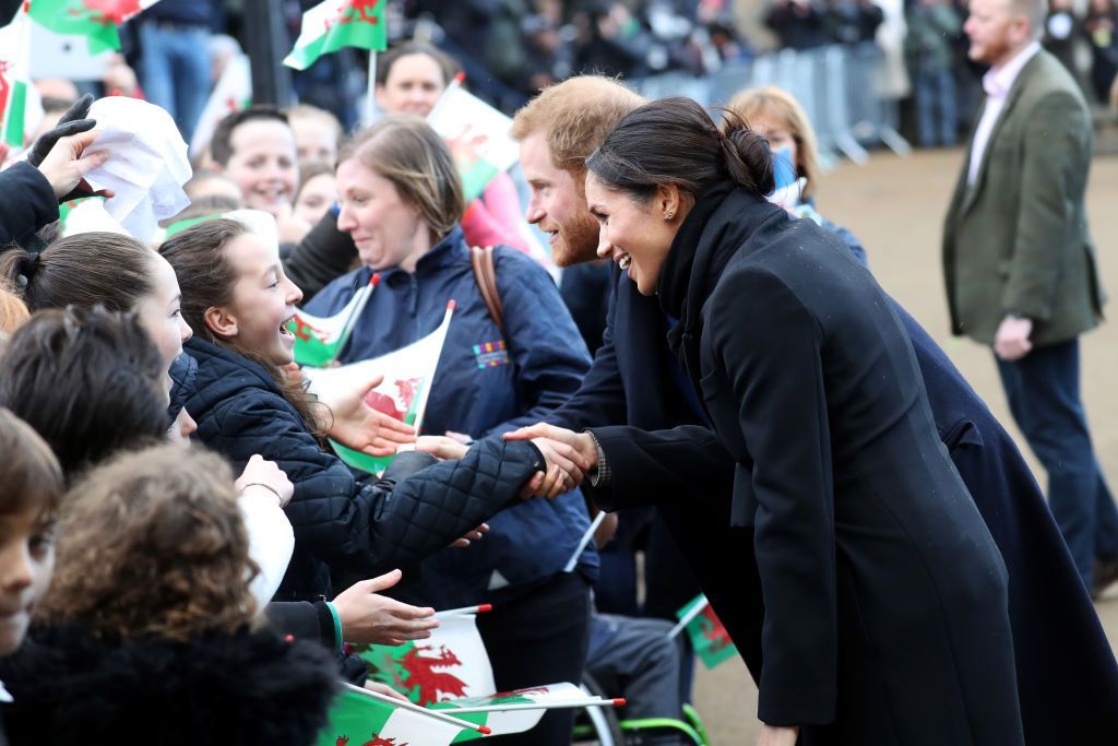 CARDIFF, WALES - JANUARY 18: Prince Harry and his fiancee Meghan Markle sign autographs and shake hands with children as they arrive to a walkabout at Cardiff Castle on January 18, 2018 in Cardiff, Wales. (Photo by Chris Jackson/Chris Jackson/Getty Images)