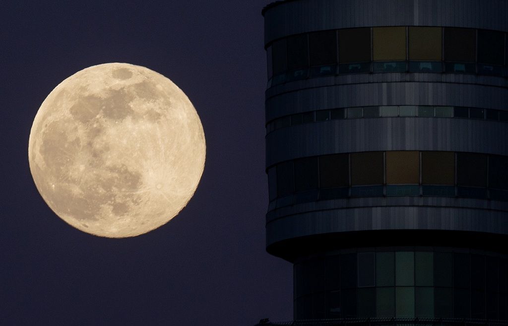 The Pink Supermoon rises next to Danube Tower (Donauturm) in an astronomical event that occurs when the moon is closest to the Earth in its orbit, making it appear much larger and brighter than usual, in Vienna, Austria, April 7, 2020.  REUTERS/Lisi Niesner