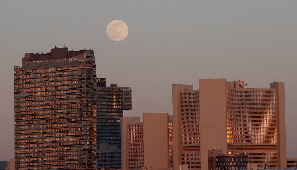 The Pink Supermoon rises above the United Nations office buildings in an astronomical event that occurs when the moon is closest to the Earth in its orbit, making it appear much larger and brighter than usual, in Vienna, Austria, April 7, 2020.  REUTERS/Lisi Niesner