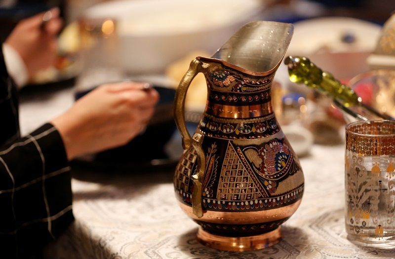 بسبب كورونا.. أقدس الأماكن الإسلامية خالية من المصلين مع بدء شهر رمضان 1 An intricate water vase sits on the table as the Almounaier-Alkabra family eats their iftar meal, which they normally eat with other relatives, on the first day of Ramadan during the coronavirus disease (COVID-19) outbreak in Bellevue, Washington, U.S. April 24, 2020. Picture taken April 24, 2020. REUTERS/Lindsey Wasson