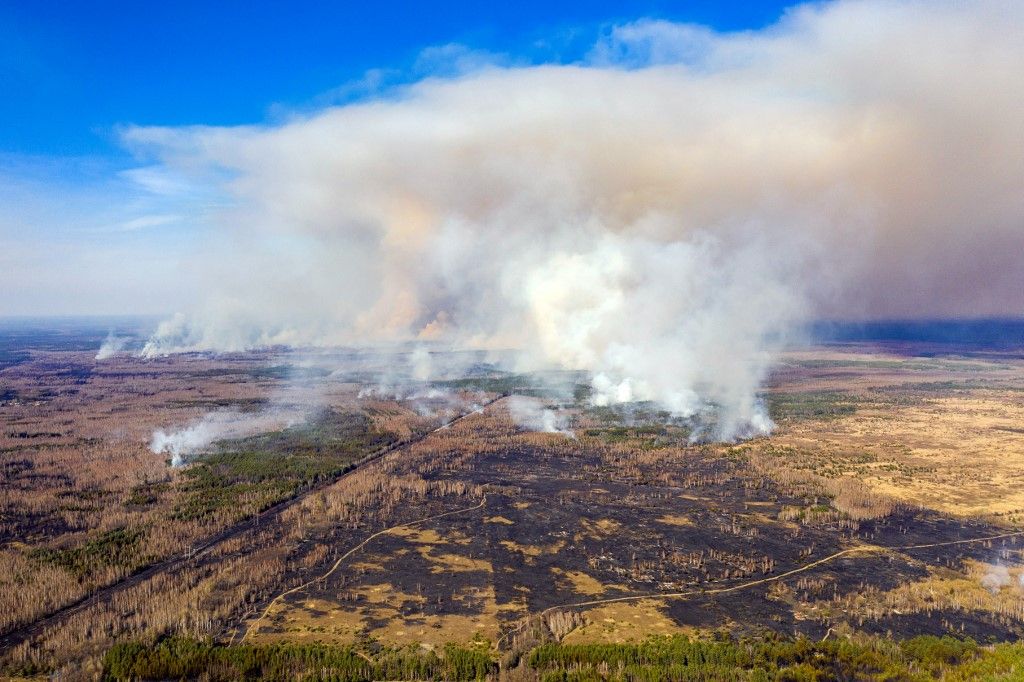 حرائق غابات واسعة في أوكرانيا تقترب من محطة تشيرنوبيل النووية 2 This aerial picture taken on April 12, 2020 shows a forest fire burning at a 30-kilometer (19-mile) Chernobyl exclusion zone in Ukraine, not far from the nuclear power plant. - Some 400 firefighters battle a blaze that broke out on April 4, 2020 in the wooded zone around the ruined Chernobyl reactor that exploded in 1986 in the world's worst nuclear accident. (Photo by Volodymyr Shuvayev / AFP)