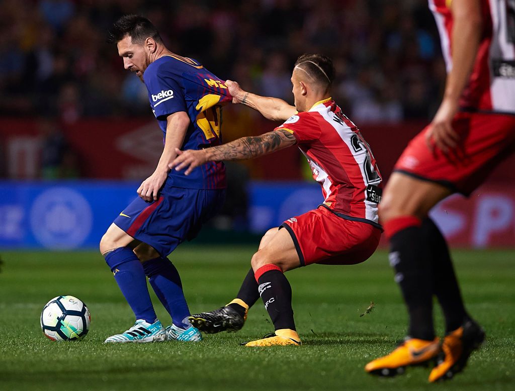 GIRONA, SPAIN - SEPTEMBER 23:  Lionel Messi of Barcelona is tackled by Pablo Maffeo of Girona during the La Liga match between Girona and Barcelona at Municipal de Montilivi Stadium on September 23, 2017 in Girona, Spain.  (Photo by Manuel Queimadelos Alonso/Getty Images)