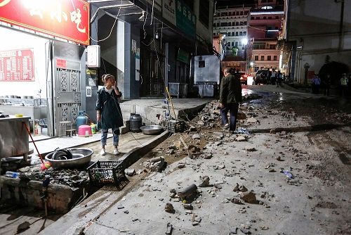 أربعة قتلى بزلزال في جنوب غرب الصين 1 A woman stands outside a restaurant after a 5.0-magnitude earthquake in Qiaojia county, Zhaotong city, in China's southwestern Yunnan province early on May 19, 2020. - Four people were killed and another 23 injured when an earthquake shook southwestern China's Yunnan province, local authorities said on May 19.