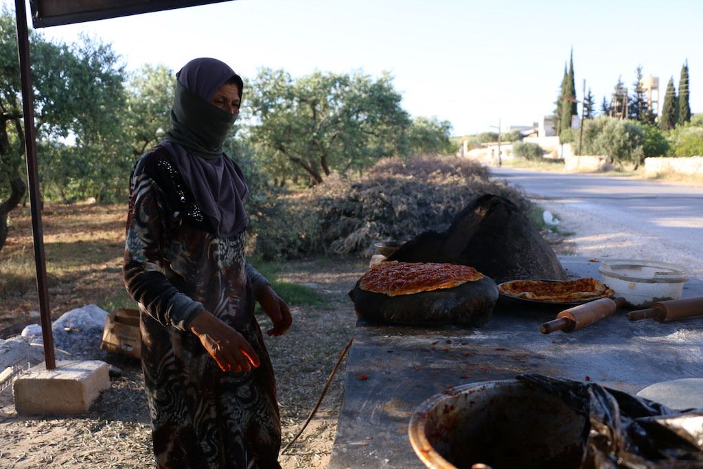 من مرارة النزوح إلى ويلات العيش.. "أم سومر" تفتتح تنوراً لسد رمق عيش عائلتها شمالي إدلب
