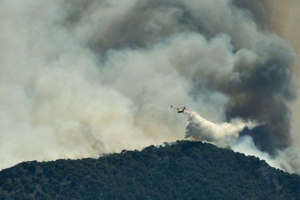 اليونان.. حريق كبيرٌ يجتاح غابة قرب قرية مطلّة على البحر (صور) 2 A firefighting plane makes a water drop as a wildfire burns near the village of Kechries, Greece, July 22, 2020. REUTERS/Vassilis Triandafyllou TPX IMAGES OF THE DAY