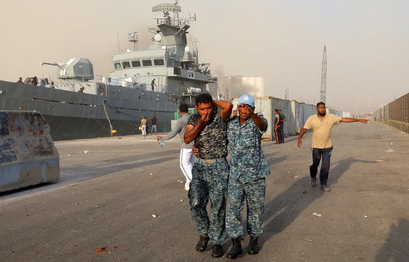  أشخاص يمشون بالقرب من موقع انفجار في بيروت ، لبنان ، 4 أغسطس 2020. رويترز