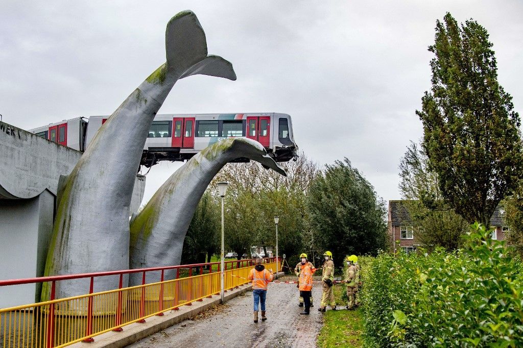 An photo taken in Spijkenisse, on November 2, 2020 shows a metro train that shot through a stop block at De Akkers metro station, without making any casualty. - A Dutch metro train was saved from disaster on November 2, 2020, when it smashed through a safety barrier but was prevented from plummeting into water by a sculpture of a whale tail. The driver of the train, who was the only person on board, was unharmed in the incident which happened just after midnight at Spijkenisse, near the port city of Rotterdam. The front carriage was left hanging 10 metres (30 feet) above the water, propped up only by the giant silver-coloured sculpture -- called, improbably, "Saved by the Whale's Tail." (Photo by Robin Utrecht / ANP / AFP) / Netherlands OUT