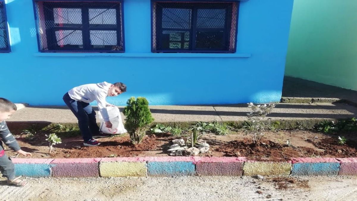 طفل يساهم في تشجير ملعب المدرسة