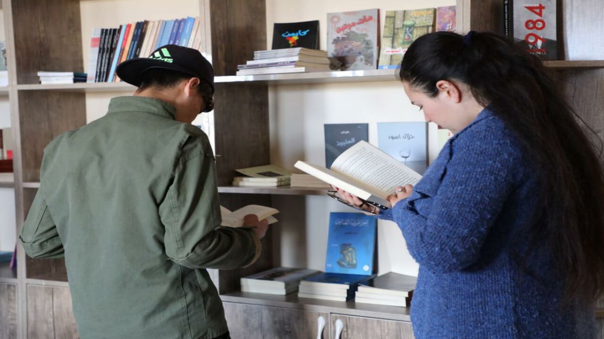 شاب وشابة يقرآن في مكتبة مدرسية بقضاء سنجار العراقي