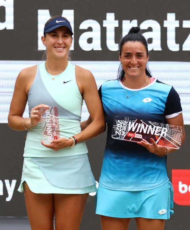 اللاعبة التونسية أُنس جابر تحمل كأبس بطولة برلين للتنس وبجانبها السويسرية بليندا بنسيتش المصنفة 17 عالميا، صاحبة المركز الثاني في البطولة. رويترز