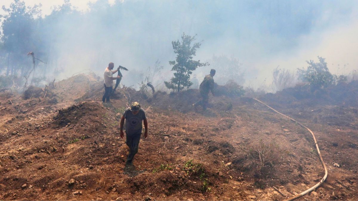 سيارة إسعاف متوقفة بالقرب من شاحنة صهريج مياه في اللاذقية. (أ ف ب)