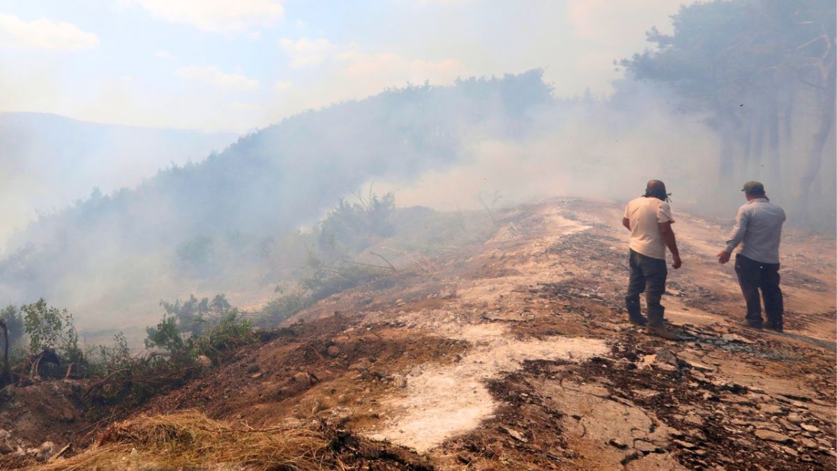 سيارة إسعاف متوقفة بالقرب من شاحنة صهريج مياه في اللاذقية. (أ ف ب)